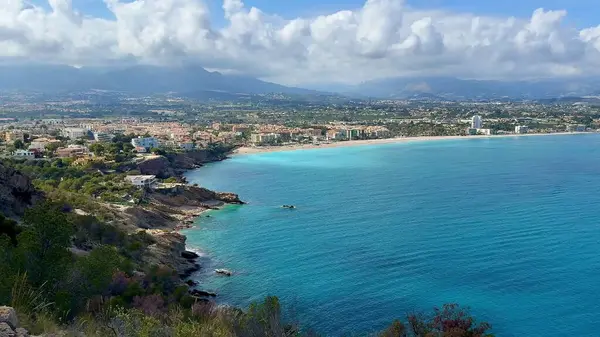 Güzel turkuaz suların ve yemyeşil yeşilliklerin yer aldığı sakin bir sahil şeridinin nefes kesici hava manzarası.