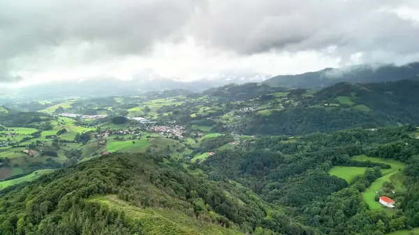 Nefes kesici bir hava manzarası, bulutlu gökyüzünün altındaki yemyeşil tepeleri, güzel vadileri ve cennet köylerini gösteriyor.