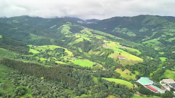 Bulutlu gökyüzünün altındaki yemyeşil tepelerin ve vadilerin büyüleyici görüntüleri doğanın güzelliğini gözler önüne seriyor..