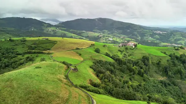 Geniş yeşil tepelerin ve bulutlu gökyüzünün altında uzanan yemyeşil vadilerin nefes kesici güzelliğini keşfedin.