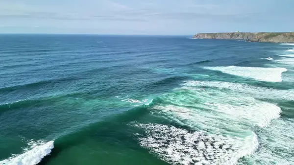 Nefes kesen bir hava görüntüsü güzel güneşli bir günde kumlu sahile vuran resimli okyanus dalgaları sergiliyor.