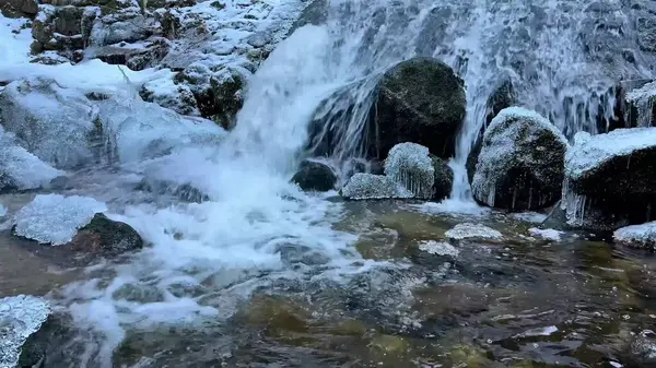Güzel bir resim gibi donmuş akarsu zarif bir şekilde kayaların üzerinden akıyor, kışların enfes güzelliklerini yakalıyor.