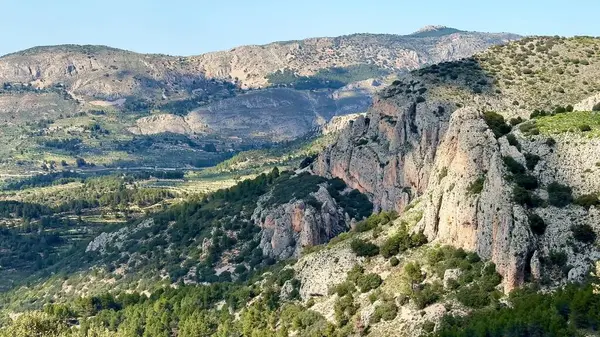 Engebeli dağların ve vadilerin göz kamaştırıcı güzelliği berrak mavi gökyüzünün altında yemyeşil bir bitki örtüsü.