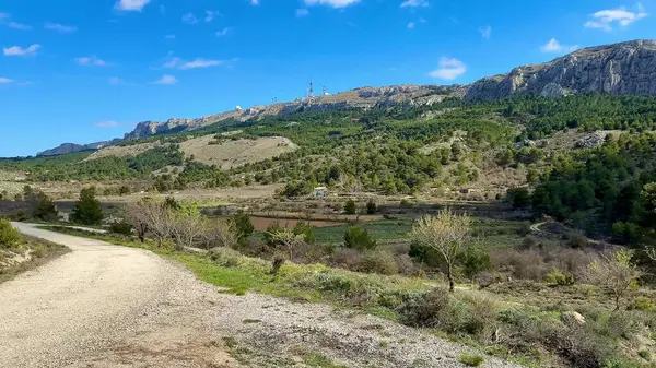 Görkemli dağların nefes kesici manzarası ve yemyeşil manzara, berrak mavi bir gökyüzünün altında uzanıyor.
