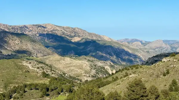 Nefes kesen manzaralar, yuvarlanan tepeler ve görkemli dağlar canlı mavi ve geniş bir gökyüzüne karşı kurulmuş.
