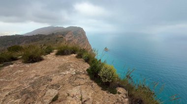 Bu nefes kesici kıyı manzarası güzel bir şekilde gökyüzünün altındaki dingin okyanus manzarasını sergiliyor.