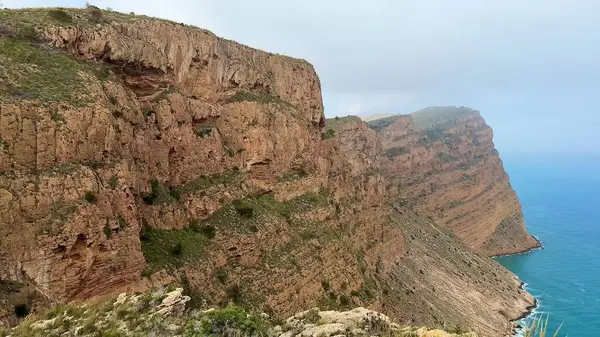 Görkemli ve yüksek kıyı kayalıkları aşağıdaki güzel turkuaz suların huzurlu ve nefes kesici manzarasını sağlar.