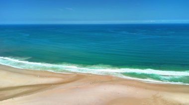 El değmemiş kumlu plajların, parlak dalgaların ve canlı mavi suların bulunduğu nefes kesici kıyı manzaralarını keşfedin.