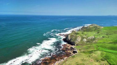 Muhteşem uçurumların, çarpan dalgaların ve kıyı boyunca yemyeşil tarlaların nefes kesici ve çarpıcı hava manzaralarının tadını çıkarın.