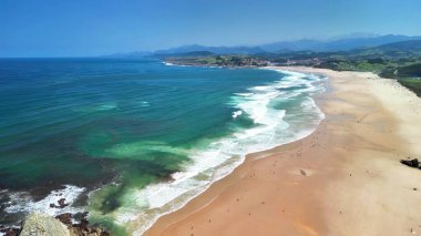 Kristal turkuvaz suları ve güzel kumlu sahil şeridi olan nefes kesici bir sahil manzarası.