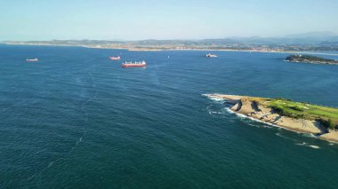 Göz kamaştırıcı bir kıyı manzarası yakalayan büyüleyici bir hava manzarası. Ufuk çizgisini noktalayan çeşitli gemilerle dolu.