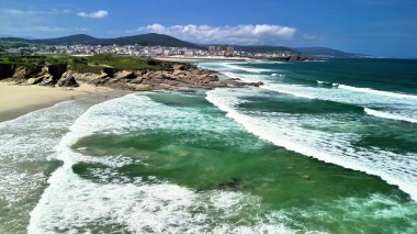 Nefes kesici sahil manzarası nefes kesici dalgalar, berrak sular ve büyüleyici bir sahil şehri.