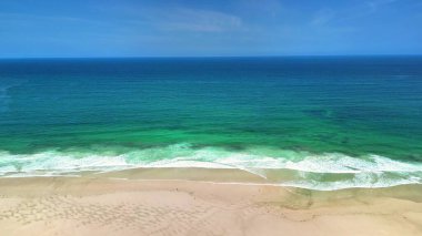 Olağanüstü çarpıcı bir hava görüntüsü muhteşem bir sahili ve canlı turkuaz okyanus dalgalarını gözler önüne seriyor.