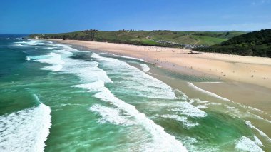 Sörfçüler ve güneşlenenler için mükemmel olan güzel bir plajın nefes kesici hava manzarasını keşfedin..