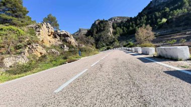 Görkemli dağların ve canlı manzaraların arasından geçen dolambaçlı bir yolun nefes kesici panoramik manzarasının tadını çıkar.