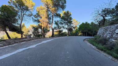 Ağaçlarla ve manzaralarla çevrili güzel, dolambaçlı bir yol. Sürüş ve maceralar için ideal..