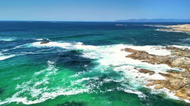 Kendinizi, turkuaz okyanus sularının ve kayalık kıyıların nefes kesici ve çarpıcı güzelliğine daldırın.