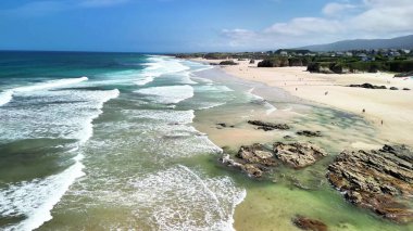 Havadan bakıldığında göz kamaştırıcı masmavi sular, beyaz kumlar ve sakin bir kumsalın nazik dalgaları görülür.