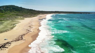 Sersemletici hava görüntülerinde büyüleyici turkuaz su ve yemyeşil çevresiyle sakin bir plaj sergileniyor.