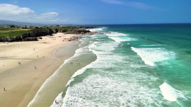Yumuşak dalgaları ve açık gökyüzü olan, rahatlamak için mükemmel güzel bir sahil manzarası..
