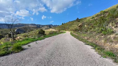 Huzurlu bir yolculuğa çık sakin bir yol boyunca parlak mavi gökyüzünün altındaki yemyeşil tepelerde dolaş.