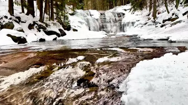Nefes kesen ve güzel bir şelale zarif bir şelaleyle sersemletici bir kar manzarasında kış boyunca ilerliyor.