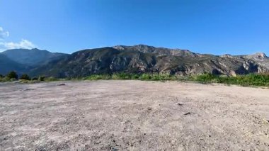 Nefes kesici ve çarpıcı bir manzara. Yüksek dağlar ve berrak mavi gökyüzünün altında canlı bir yeşillik.