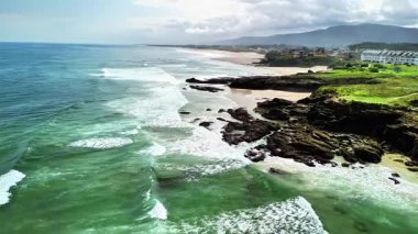 Muhteşem bir sahil manzarası. Dalgalar, kayalık kıyılara ve kumsallara çarpıyor.