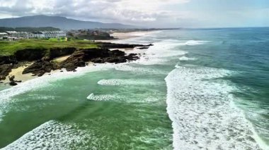 Karşınızda çarpıcı bir hava manzarası canlı okyanus dalgaları kıyı boyunca yemyeşil kayalıklara çarpıyor.