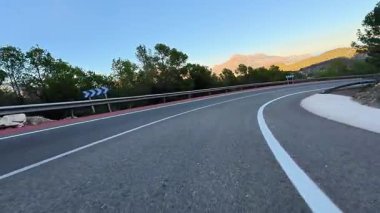 Dönen bir yol görkemli dağların arasından geçer, yemyeşil, ve açık mavi gökyüzü, maceracılar için idealdir.