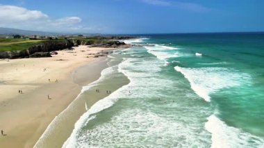 Yumuşak dalgaları ve açık gökyüzü olan, rahatlamak için mükemmel güzel bir sahil manzarası..