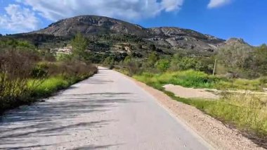 Resimli ve büyüleyici bir yol, verimli, canlı yeşillikler ve görkemli dağların arasında güzel bir şekilde dönüyor.