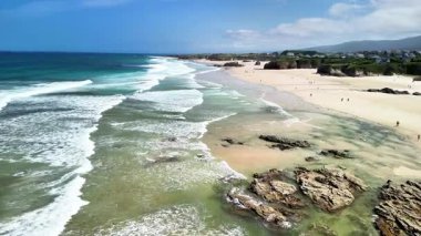 Havadan bakıldığında göz kamaştırıcı masmavi sular, beyaz kumlar ve sakin bir kumsalın nazik dalgaları görülür.