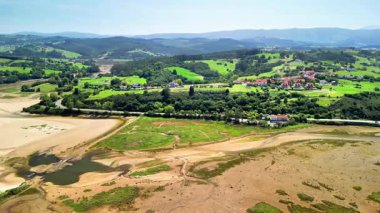 Havadan bakıldığında yemyeşil ve yuvarlanan tepeler arasında kurumuş bir nehir yatağı görünüyor. Nefes kesen güzellikleri vurguluyor.