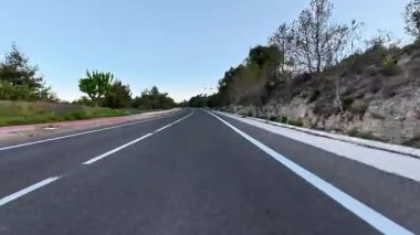 Bereketli yeşillik ve ağaçlarla çevrili huzurlu ve huzurlu bir yolun resimsel ve çarpıcı manzarası.