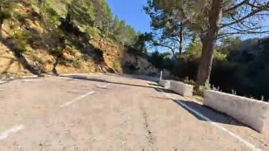 Güzel, dolambaçlı dağ yolu, bereketli ağaçlar ve yuvarlanan tepelerle çevrili, heyecan verici bir keşif için mükemmel.