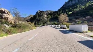 Görkemli dağların ve canlı manzaraların arasından geçen dolambaçlı bir yolun nefes kesici panoramik manzarasının tadını çıkar.