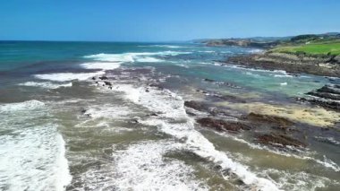 Çarpıcı hava görüntüleri dinamik dalgaları ve okyanusun engebeli kıyı şeritlerini güzel bir şekilde gösteriyor.