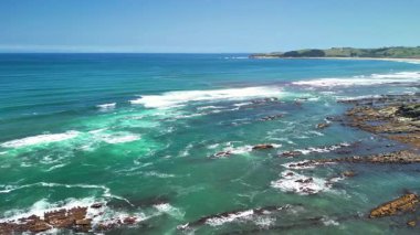 Kristal berrak turkuaz suları ve yemyeşil sularıyla sakin bir sahil şeridinin nefes kesici manzarasına hayret edin.