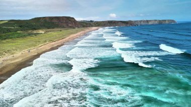 Bu çarpıcı hava manzarası dalgaları, kumlu kıyıları ve nefes kesici sahil boyunca yemyeşil alanları sergiliyor.