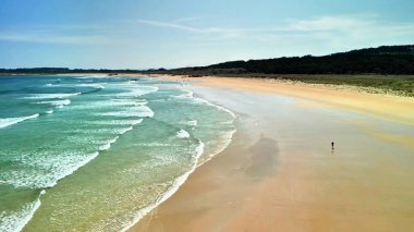 Muhteşem bir sahil sahnesi yumuşak dalgalar ve altın kumlar sergiliyor, rahatlamak ve doğa aşıkları için mükemmel..