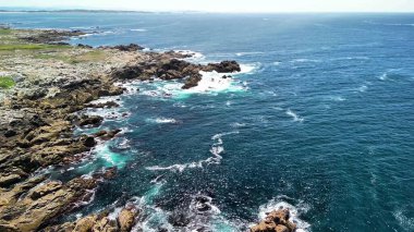 Hava görüntülerine göre çarpıcı kayalık kıyı şeridi canlı, kristal berrak turkuaz sularla birleşiyor.