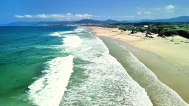 Nefes kesici bir sahil manzarası. Nazik dalgalar süzülüyor. Çok güzel bir sahil şeridi.