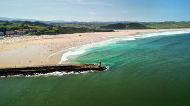 Sıcak, altın kumda dalgalar ve güneş banyosu yapan el değmemiş bir kumsalın nefes kesen manzarasının tadını çıkarın.