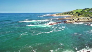 Çarpıcı insansız hava aracı görüntüleri canlı mavi suları ve engebeli kayalık kıyıları olan güzel bir kıyı şeridi gösteriyor.