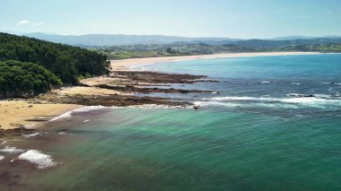 Çarpıcı turkuaz suları, yumuşak kumları ve canlı yeşillikleri olan olağanüstü bir sahili keşfedin.