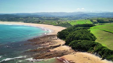Havadan bakıldığında yemyeşil ve engebeli kayalarla çevrili sakin bir sahil görünüyor. Resimli bir manzara yaratıyor.