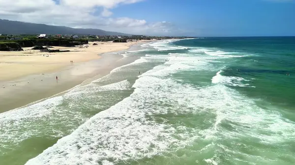 Göz kamaştırıcı ve resimli plaj manzarası yumuşak dalgalar, yumuşak kumlu kıyılar ve mükemmel derecede açık mavi bir gökyüzü.