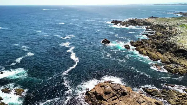 Kıyı şeridinin nefes kesici hava manzarası, kayalık oluşumlara çarpan turkuaz dalgalar..