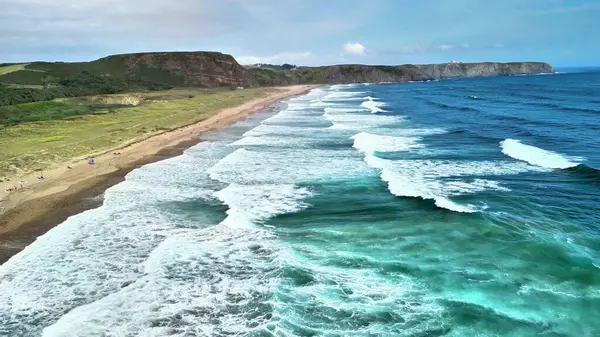 Bu çarpıcı hava manzarası dalgaları, kumlu kıyıları ve nefes kesici sahil boyunca yemyeşil alanları sergiliyor.
